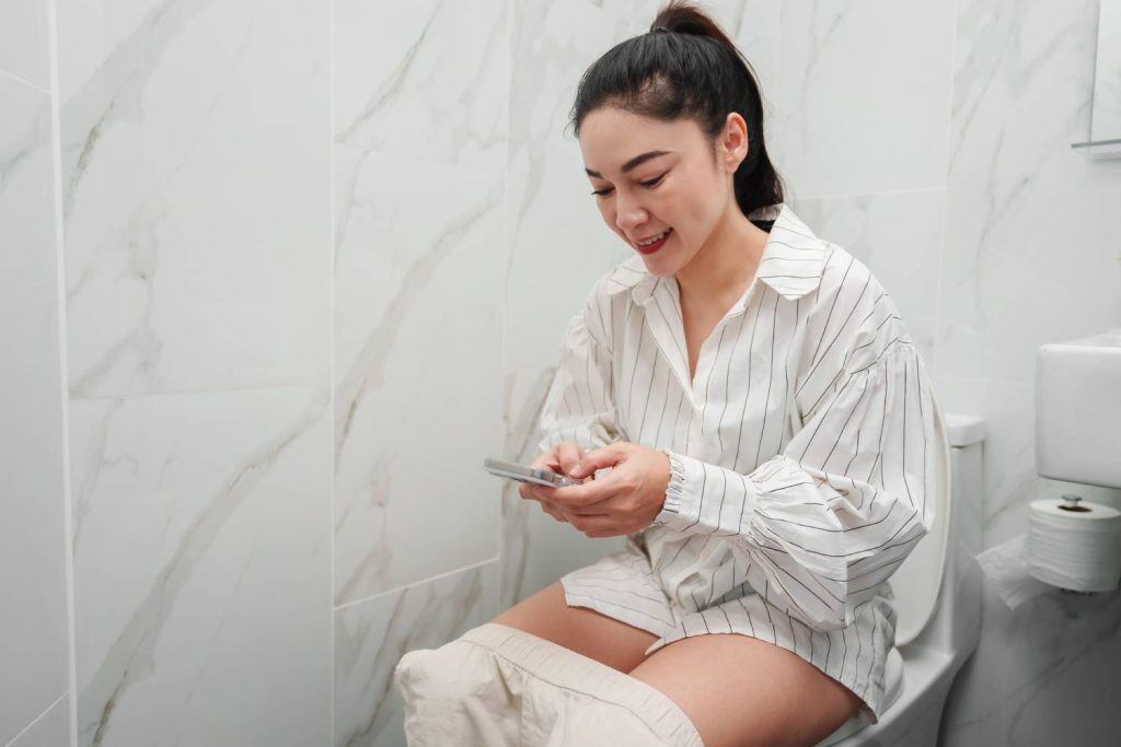 A woman sitting on the toilet comfortably