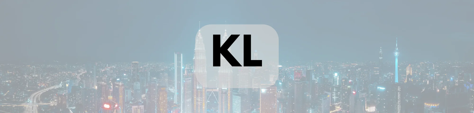 nighttime Kuala Lumpur skyline with illuminated skyscrapers and the letters “KL” prominently displayed in a translucent rounded rectangle.